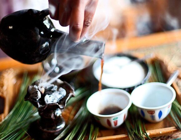 Traditional Ethiopian coffee ceremony with frankincense smoke, clay jebena, and finjal cups