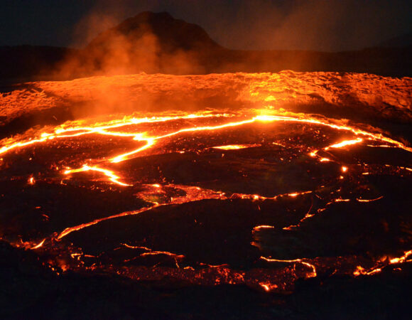 Glowing molten lava lake inside the active crater of Erta Ale volcano in Danakil Depression