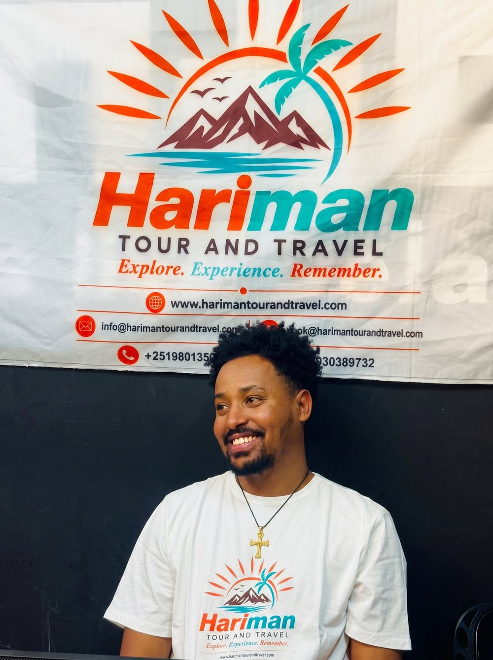 Owner and manager of Hariman Tour And Travel in front of the company banner