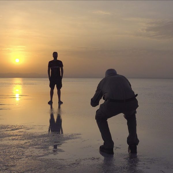 Travellers on the flooded salt flats of the Danakil at sunset