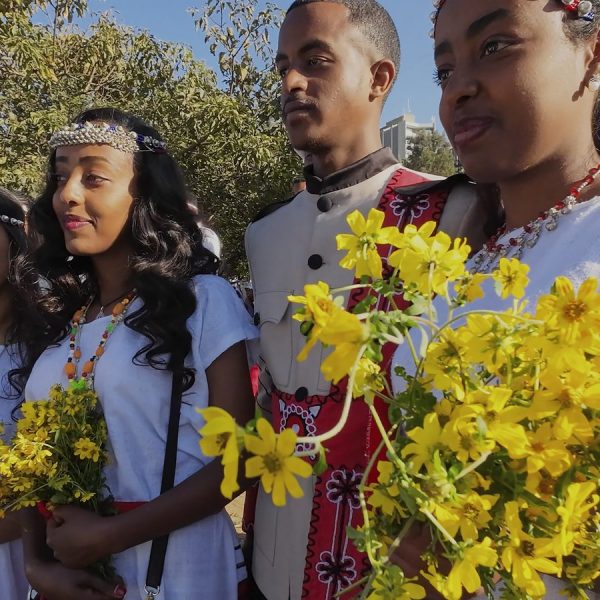 Young celebrants holding yellow Adey Abeba flowers at Irreecha