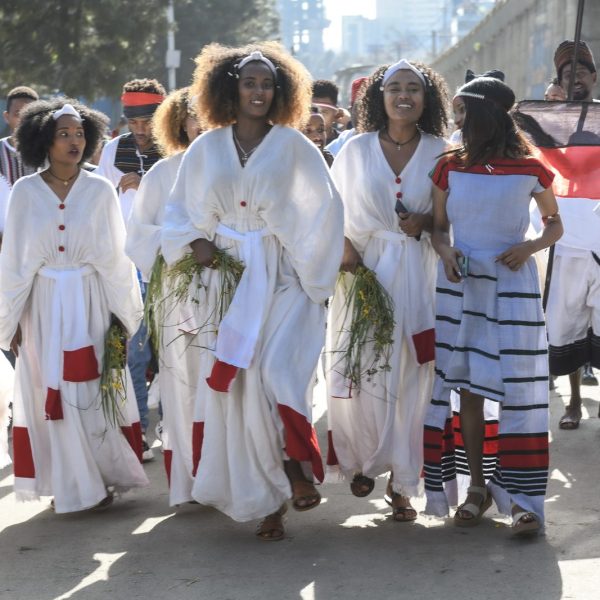 Celebrants in white traditional dress walking to Irreecha